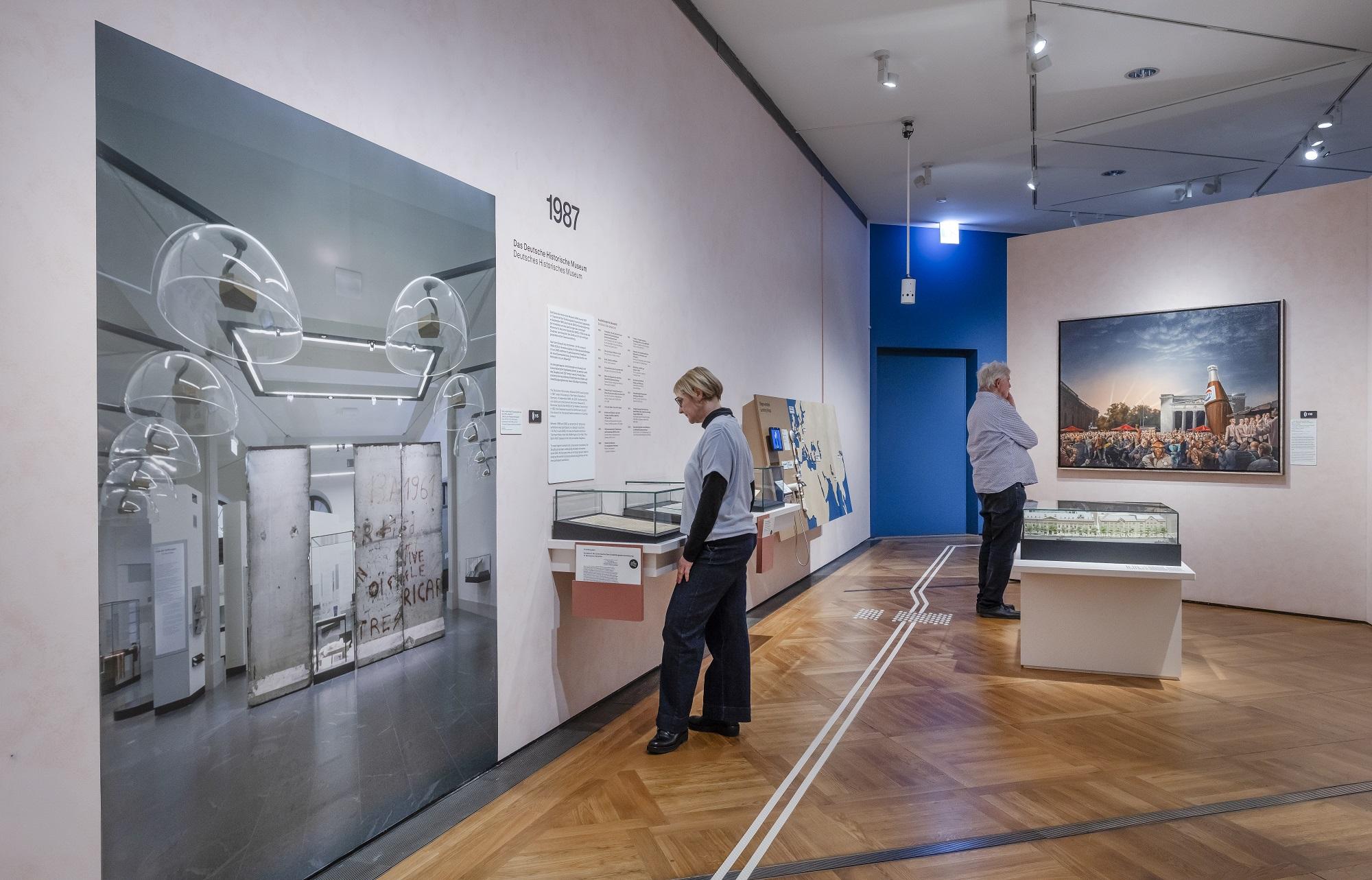 -	Blick in die Ausstellung mit dem Gemälde „…und alles wird wieder gut. Der 3. Oktober `90 vor der Neuen Wache, Berlin“ von Matthias Koeppel. 