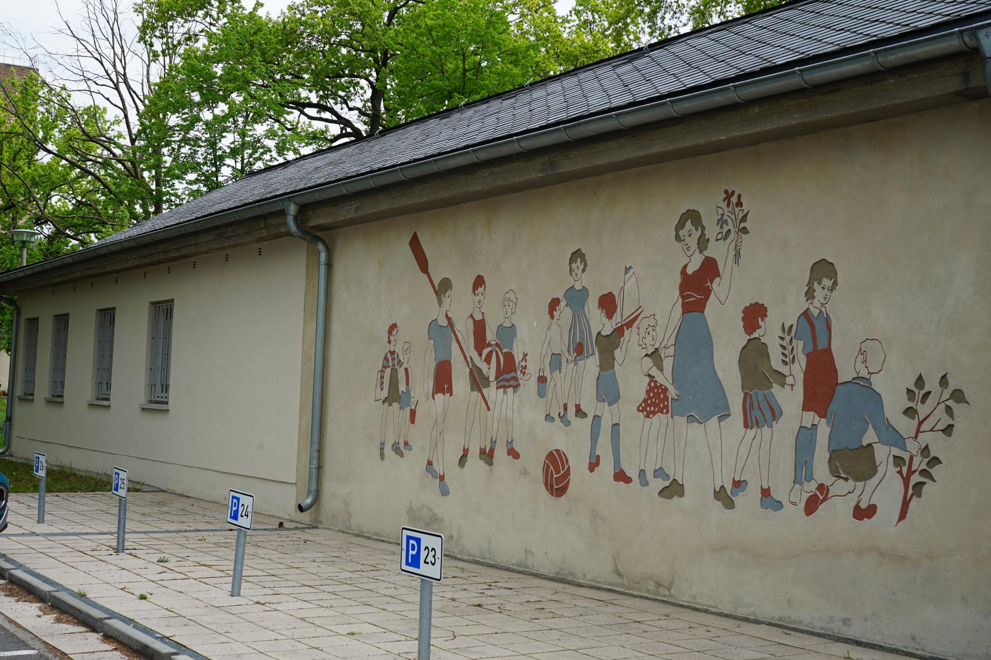 Eine Wand mit einer Malerei von Kindern, auf dem Gelände des IBZ Königsheide.