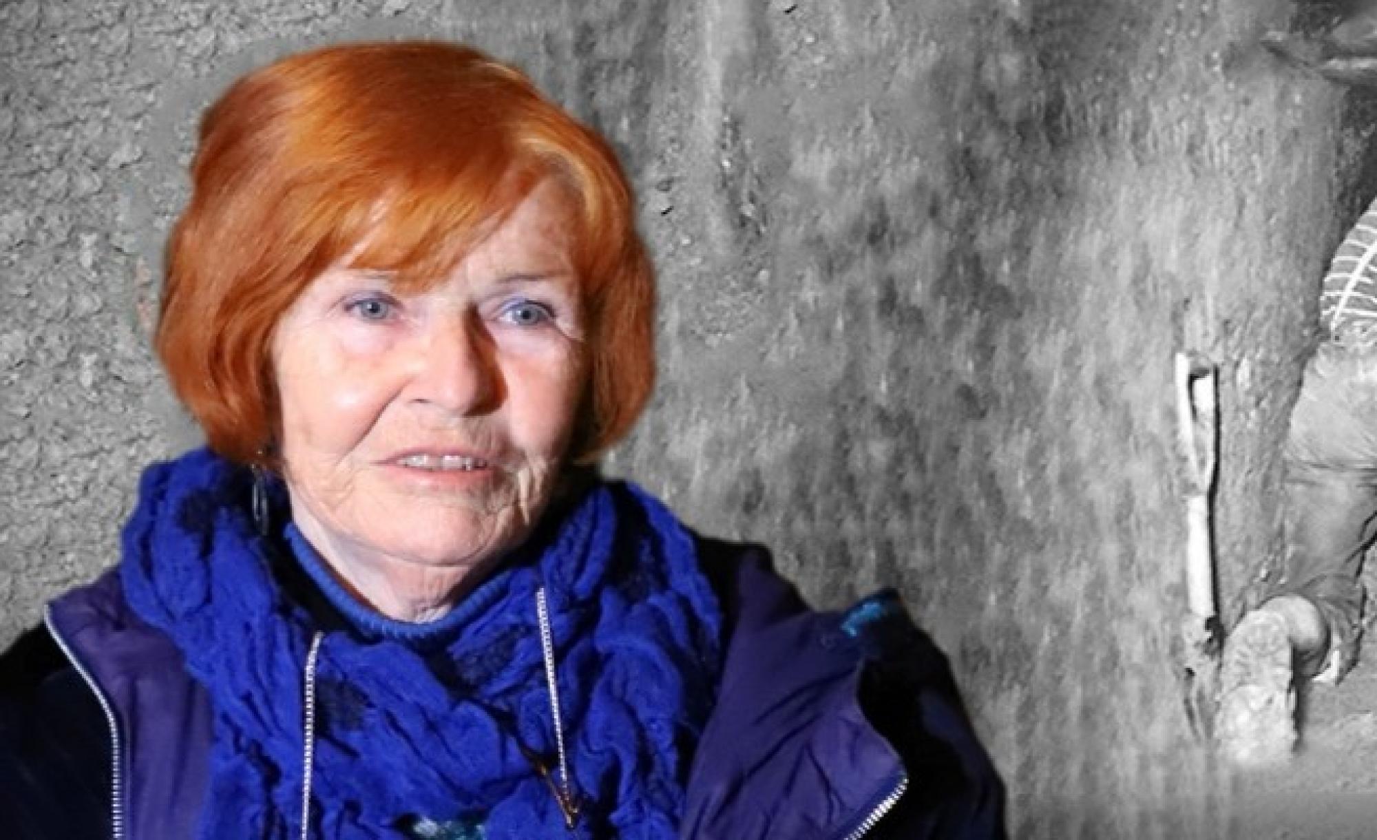 Ein Bild von Eveline Rudolph, einer Frau mit roten Haaren, vor einem Fluchttunnel in schwarzweiß.