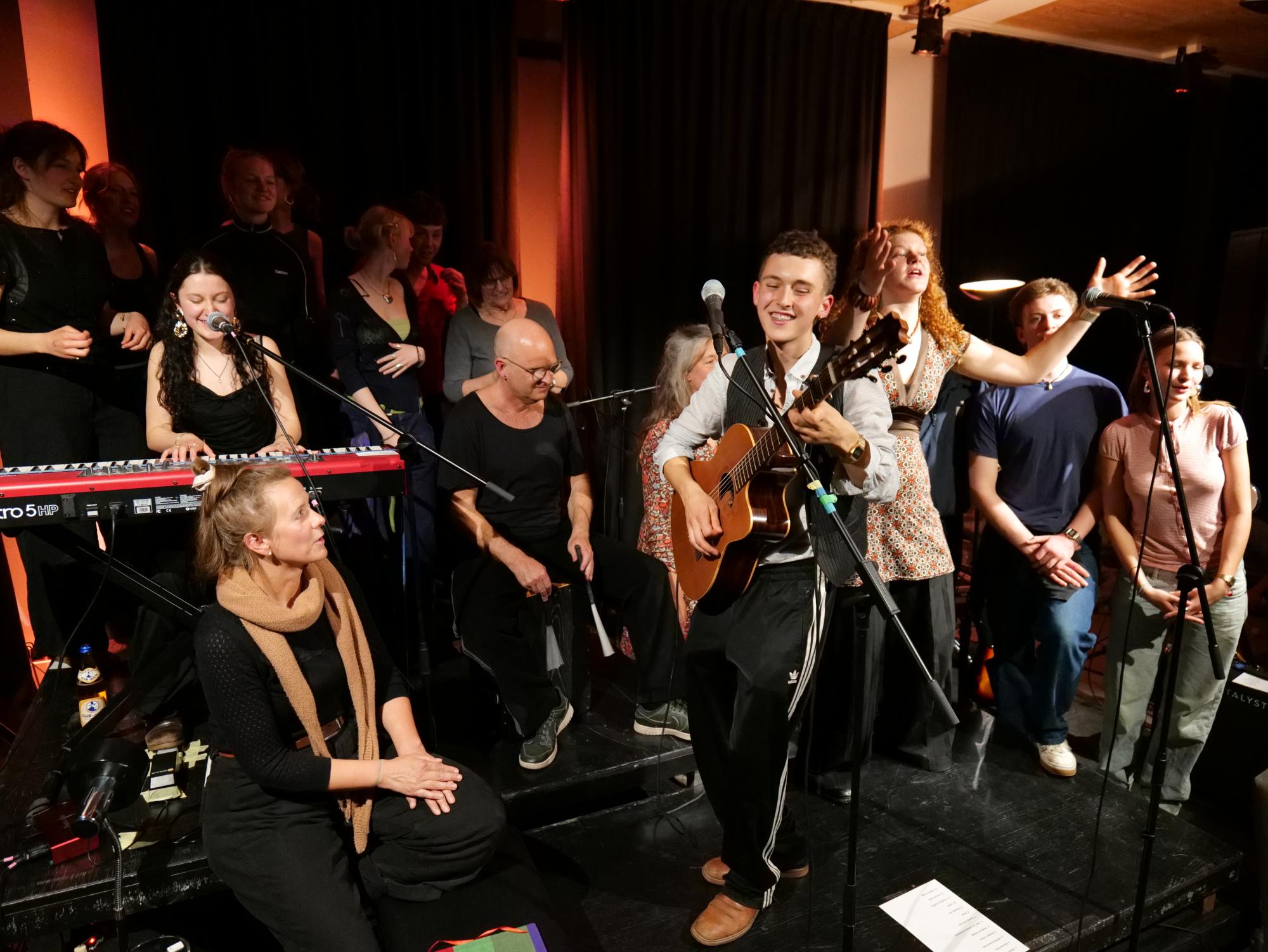 Ein Konzert, Menschen musizieren und singen auf einer Bühne.