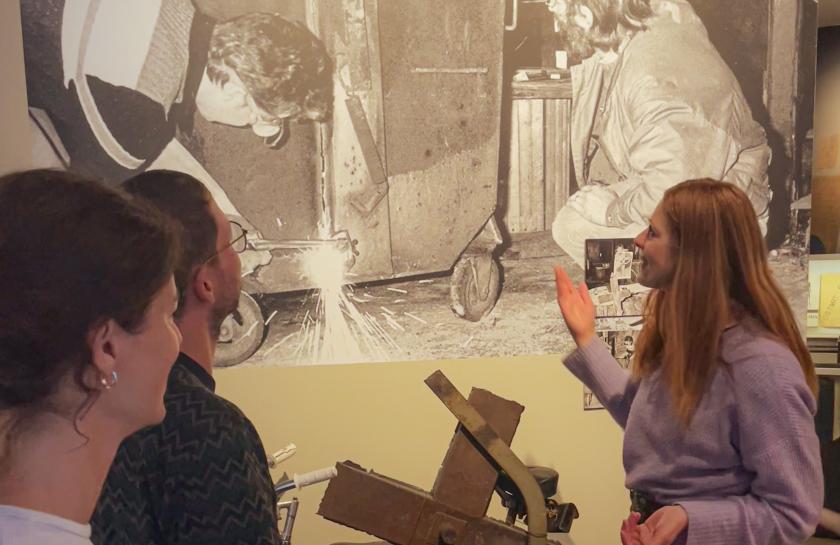 Besucher:innen betrachten ein historisches Foto im Museum in der Kulturbrauerei, das DDR-Alltagsszenen zeigt.