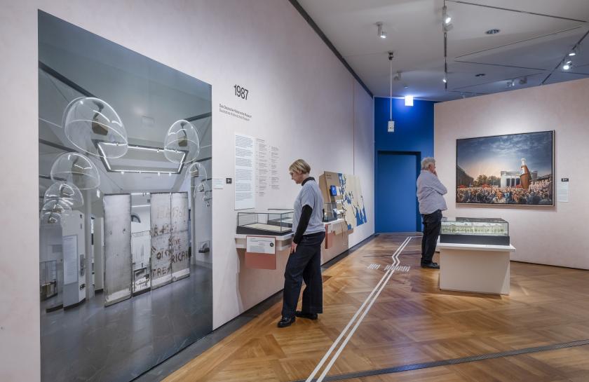 -	Blick in die Ausstellung mit dem Gemälde „…und alles wird wieder gut. Der 3. Oktober `90 vor der Neuen Wache, Berlin“ von Matthias Koeppel. 